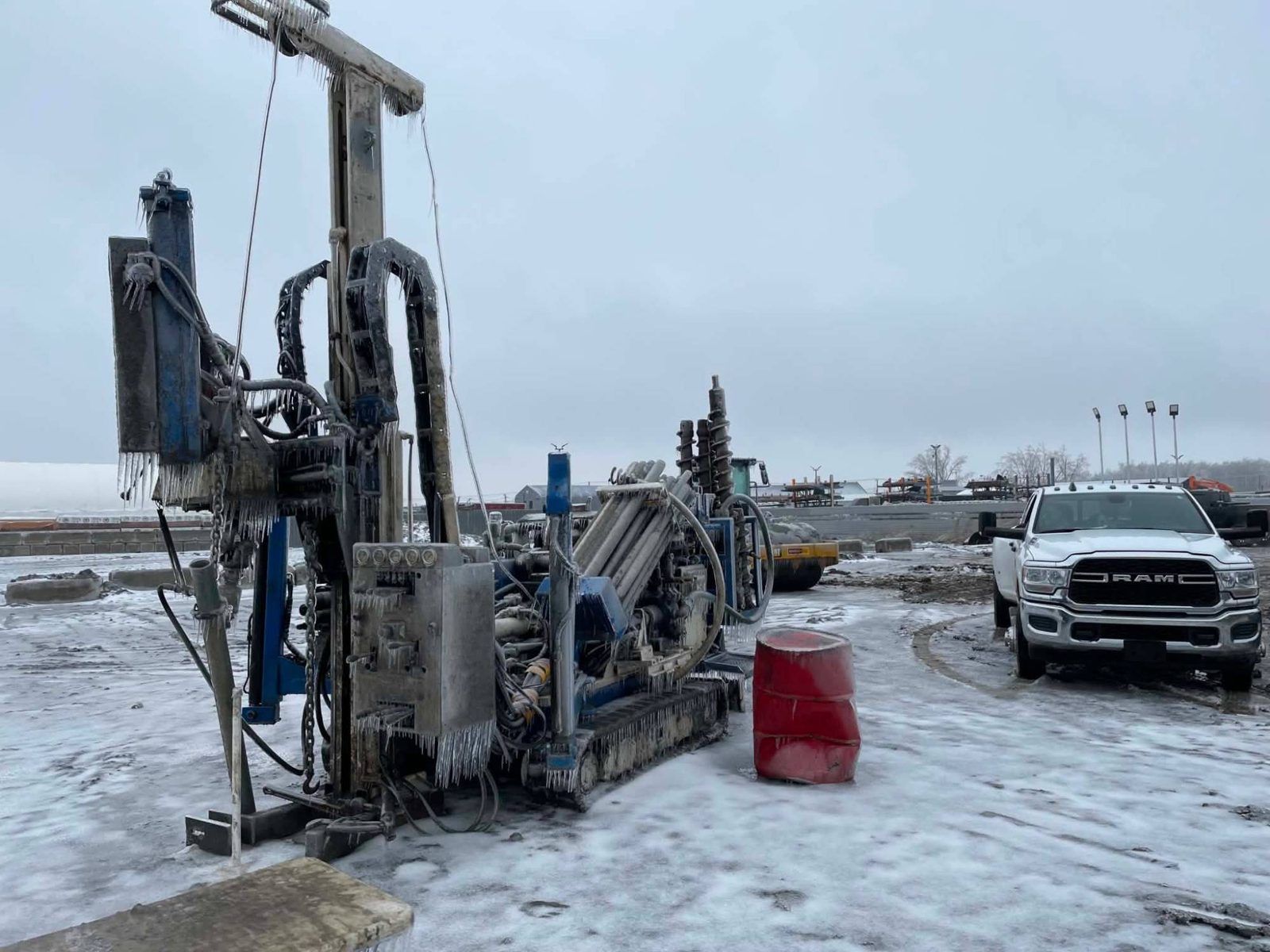 Foreuse couverte de glace après une tempête de verglas, camion de service à côté